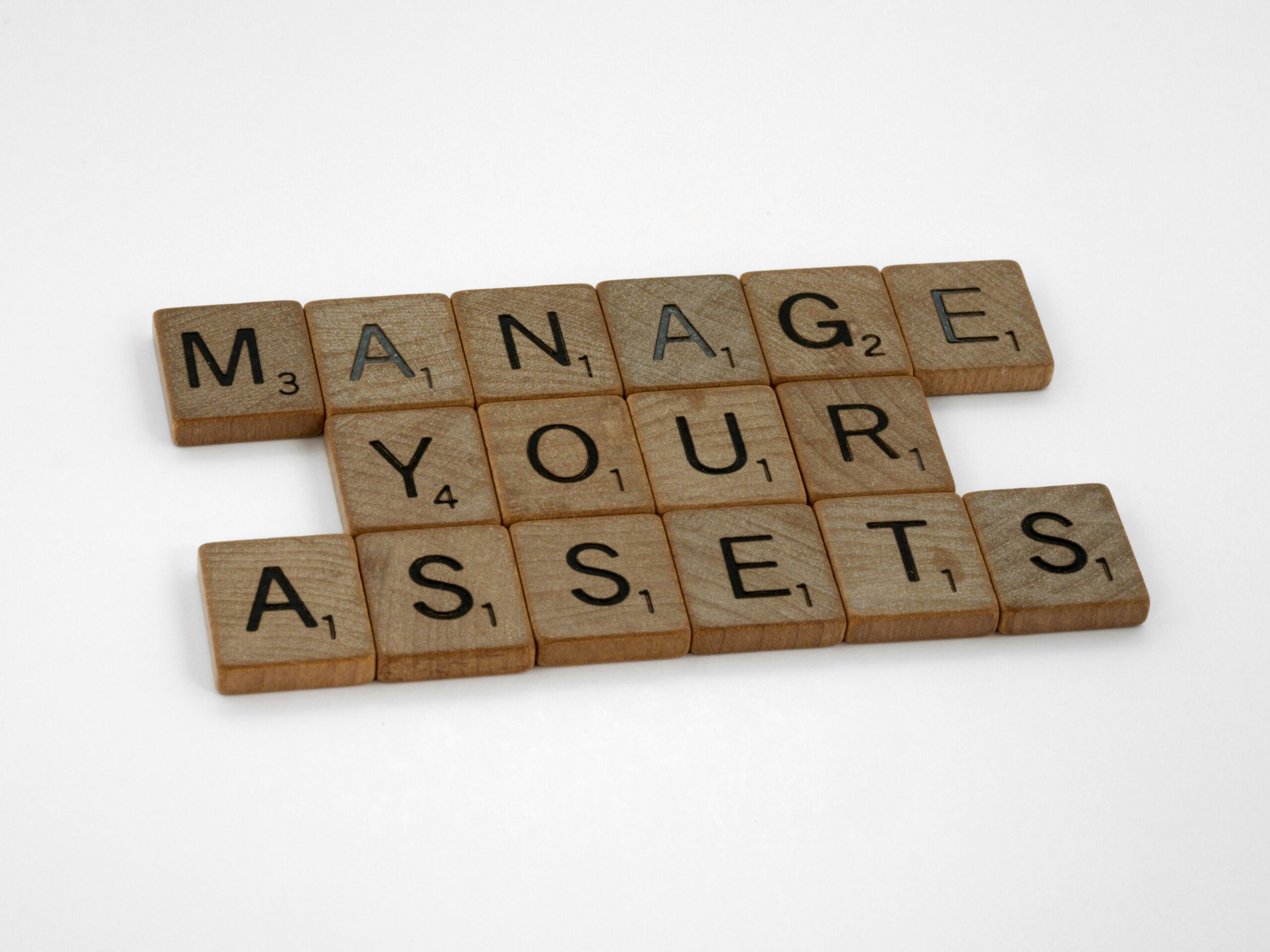 Home Wooden tiles spelling 'Manage Your Assets' offer conceptual business advice.